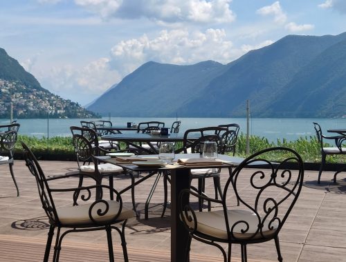 Tables and chairs with a view of a lake and mountains